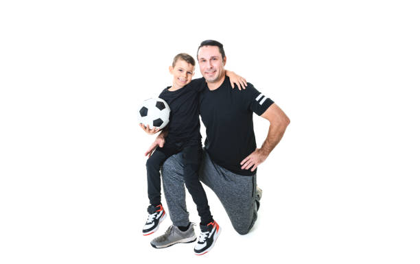 istock Young man and a boy with a soccer ball isolated on white background 1461664860