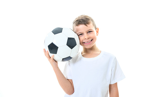 A young and cute caucasian boy with soccer ball