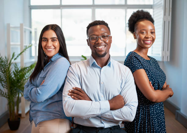 istock Group of smiling business people pose arms folded in office, diverse trio 1461666233