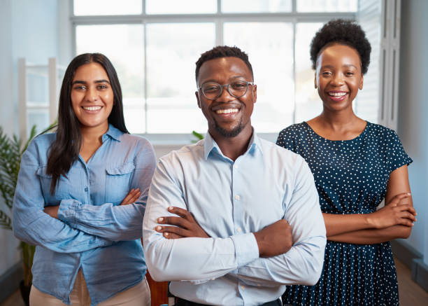 istock Group of smiling business people pose arms folded in office, diverse trio 1461666290