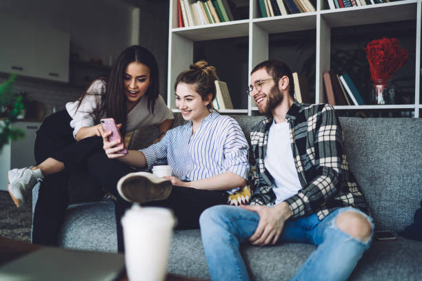 istock Young female student showing smartphone to friends 1461670550