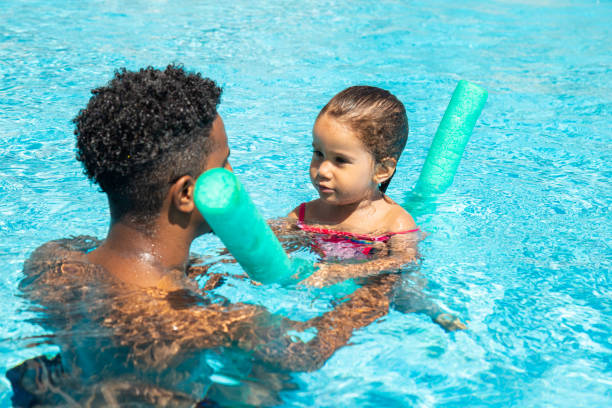 istock Father and daughter having fun in pool 1461673996