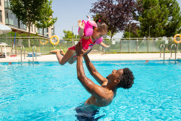 istock Father and daughter having fun in pool 1461674075