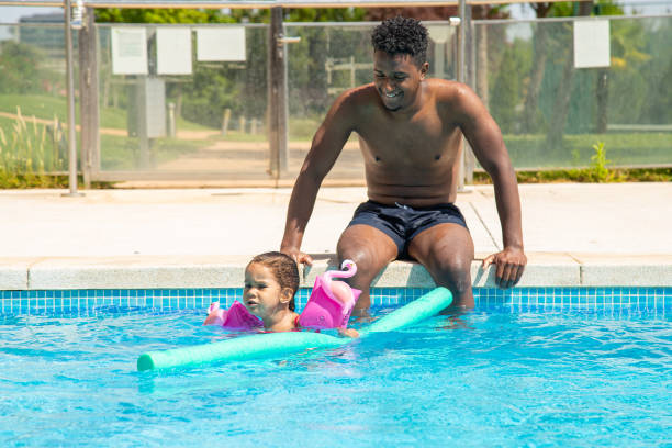 istock Father and daughter having fun in pool 1461674154
