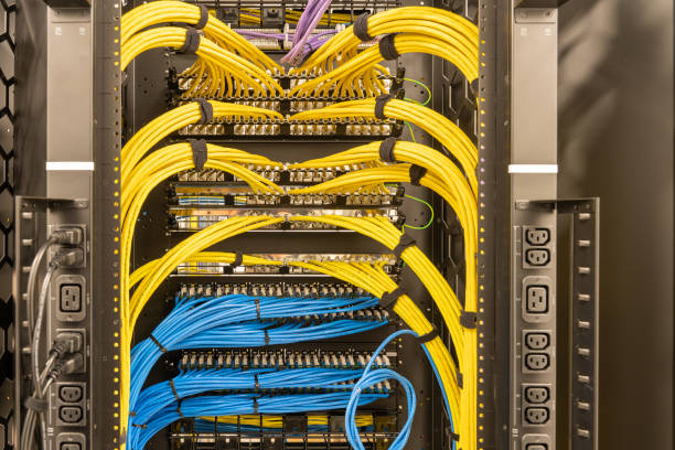 Tidy patched network cables, RJ45, connected to the switches and routers, data centre Rack with power sockets on a side, multiple switches and routers with tidily patched network cables, RJ45, data centre, networking computer cable stock pictures, royalty-free photos & images