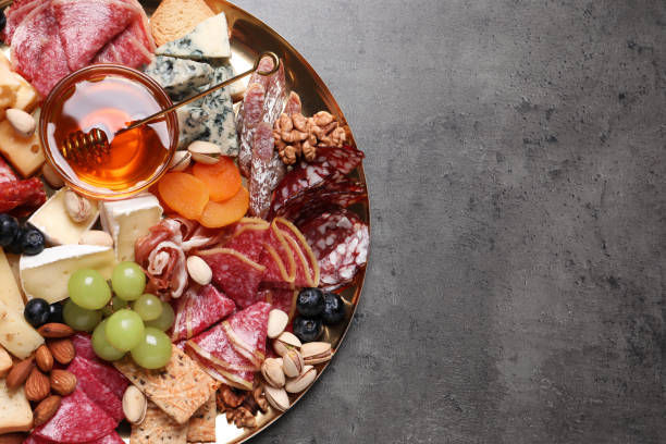 istock Plate of different appetizers with honey on grey table, top view. Space for text 1461675692
