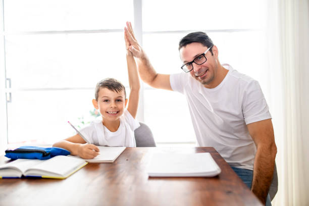 istock Father and son doing homework together at home 1461676255