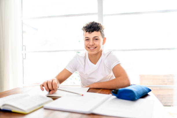 istock teen sitting at the table, writing homework or preparing for the exam 1461676266