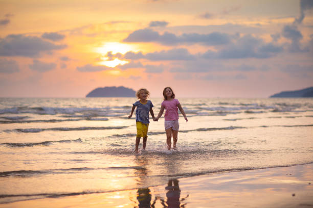 istock Child playing on ocean beach. Kid at sunset sea. 1461678127