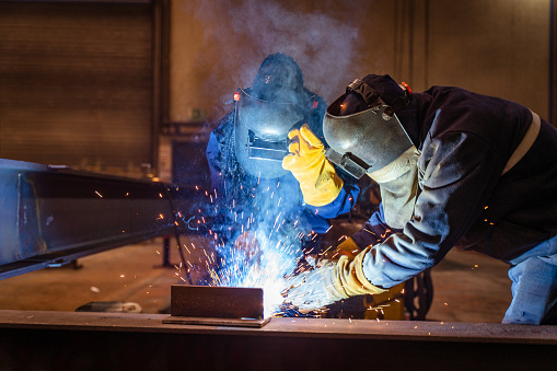 welder works in metal construction - construction and processing of steel components