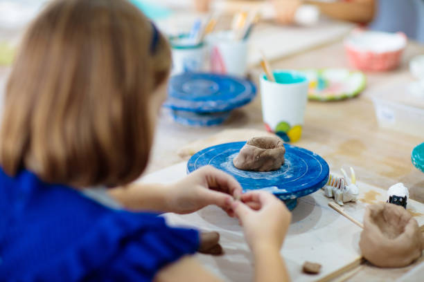 istock Child at pottery wheel. Kids arts and crafts class 1461679475