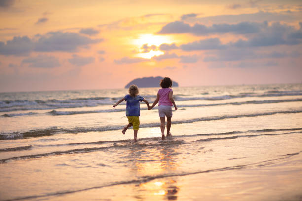 istock Child playing on ocean beach. Kid at sunset sea. 1461679697