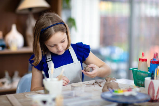 istock Child at pottery wheel. Kids arts and crafts class 1461679903
