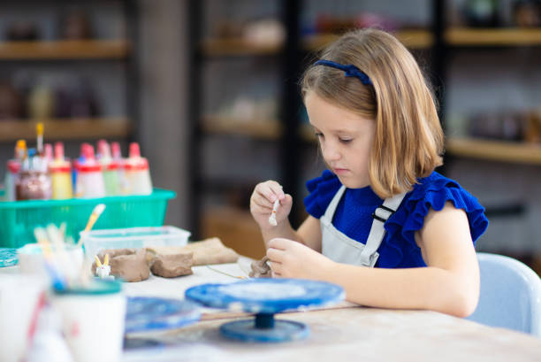 istock Child at pottery wheel. Kids arts and crafts class 1461680536
