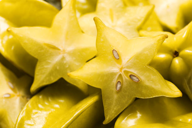 Cut and whole carambolas as background, closeup