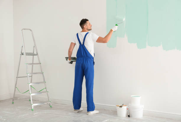 istock Man painting wall with light blue dye indoors 1461683240