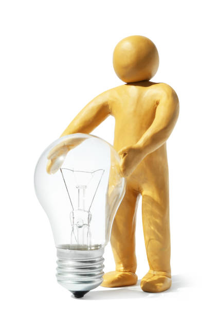 istock Human figure made of plasticine holding light bulb isolated on white 1461683335