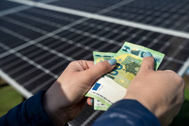 istock Human hands with euro fan in front of solar panels. 1461684831
