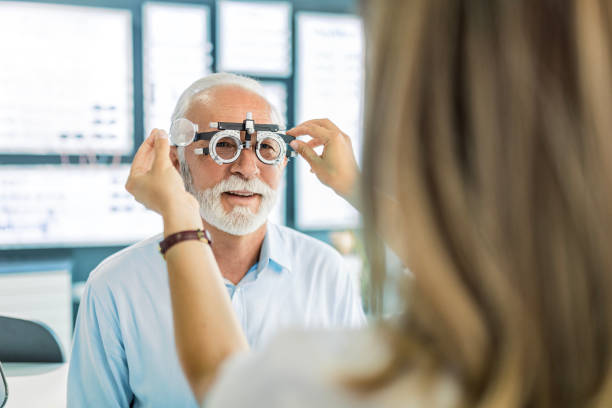 istock Smiling young woman testing eyesight for a senior patient at optic store 1461685418