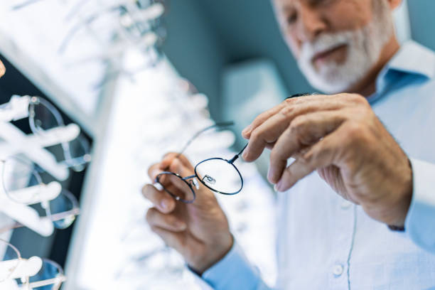 istock Senior man looking at different eyeglasses to buy ,focus on eyewear 1461685428