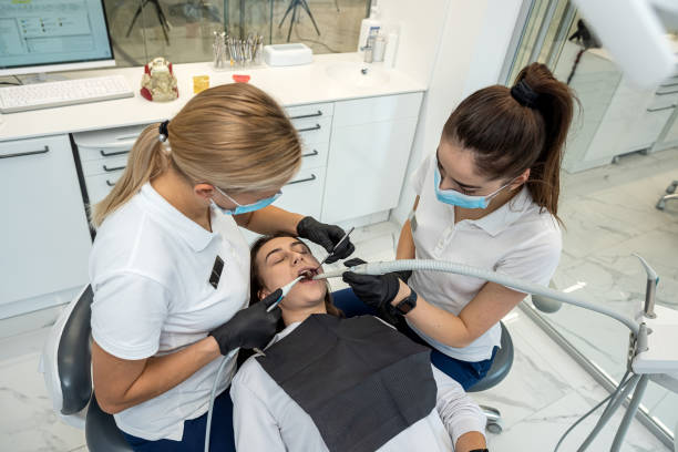 여성 치과 의사는 최신 장비로 젊은 여성 환자의 치아를 치료합니다. - dentists chair dental equipment dentist office dental drill 뉴스 사진 이미지