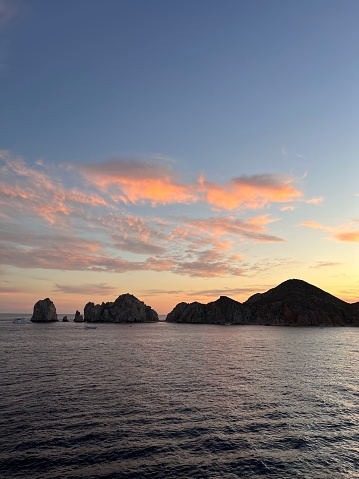 Sunset in Cabo San Lucas, Mexico with clouds, rock formation and ocean