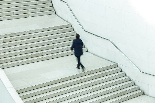 A speeding man runs up an elegant staircase in the city - the long exposure enhances the sense of movement.