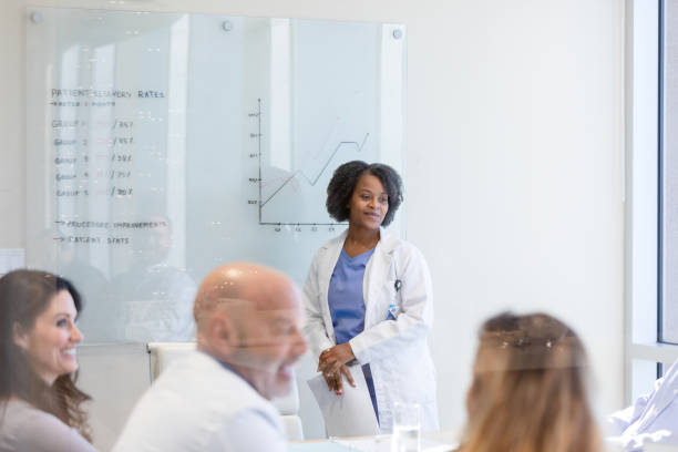 istock While colleagues chat, female staff physician waits to begin presentation 1461688254
