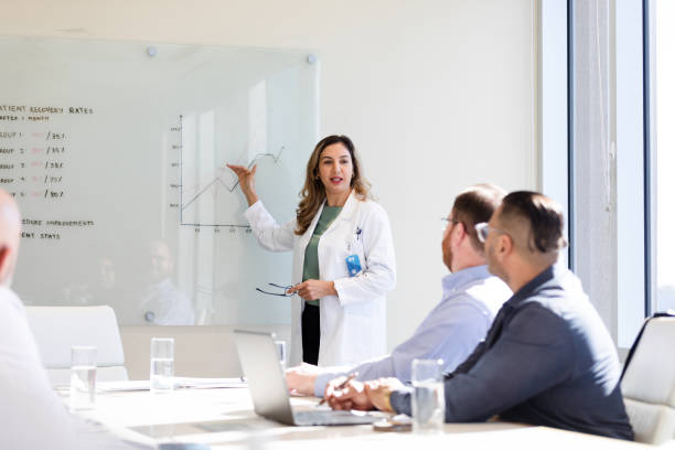 istock Female doctor explains graphs on white board to staff 1461688316