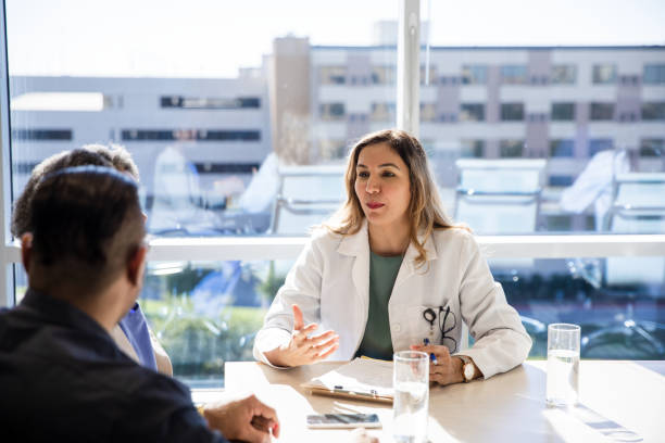 istock Female doctor gestures while answering unrecognizable couple's questions 1461688367