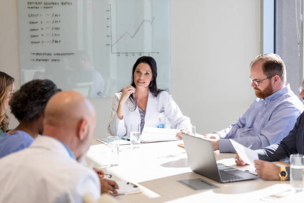 istock Female doctor leads team discussing patient issues in hospital 1461688500
