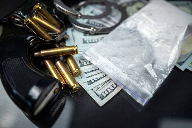 코카인 또는 헤로인의 비닐 봉지와 총에서 수갑과 총알이 든 미국 달러 지폐. - narcotic gun medicine currency 뉴스 사진 이미지