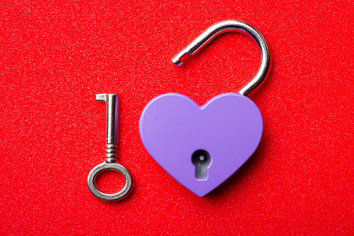 Little heart lock and key on red background