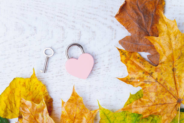 istock Love message in autumn leaves. Clean notebook and heart-shaped lock on white background. Copyspace. 1461692369