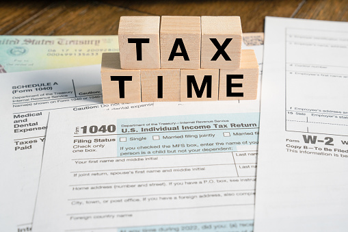 Tax Time reminder in wooden blocks with IRS Forms