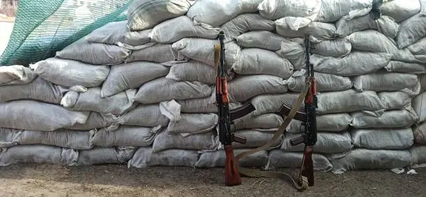 Photo of Two Kalashnikovs standing near sandbagged fortifications. AK-74 outdoor