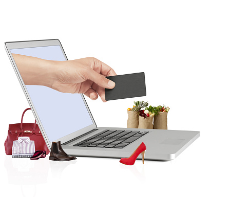 Hand holding credit card coming out of a laptop screen fro payment of online shopping