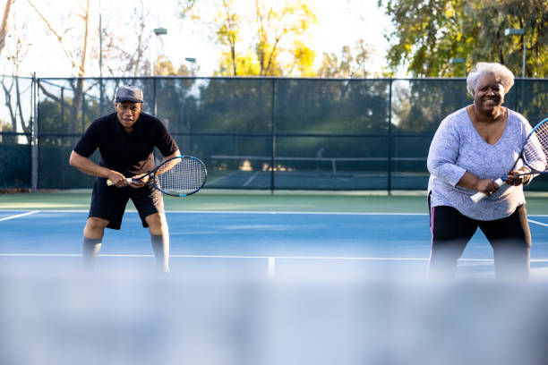 istock Senior Black Couple Playing Doubles Tennis 1461715560