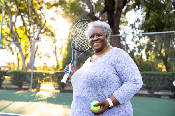 Senior Black Woman Playing Tennis stock photo