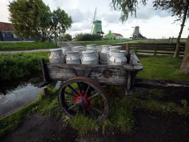 Photo of Old historic vintage traditional wooden milk cart wagon with steel cans in Zaanse Schans Amsterdam Holland Netherlands