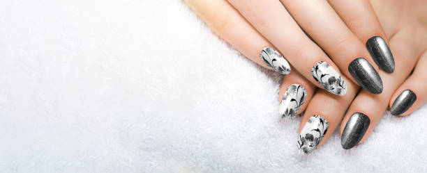 istock A black flower manicure on long, sharp nails closes up on a white background. 1461734852