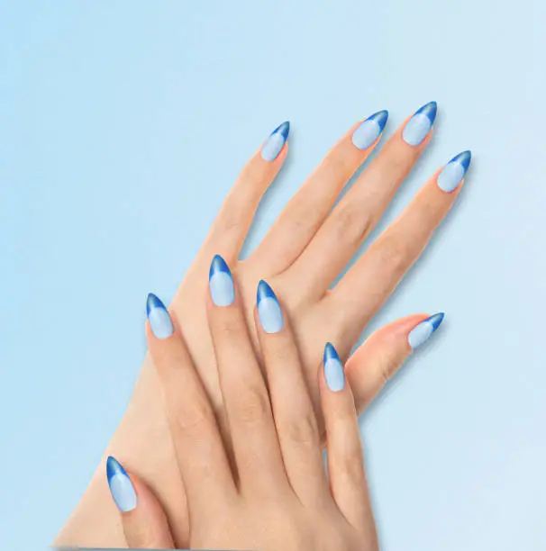 Hands With Bright Light Blue Manicure On light Blue Background. Close Up Of Female Hands With Trendy Light Blue Nails On Blue Background.