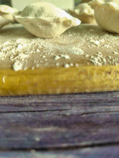 Raw homemade dumplings with potatoes on a wooden board close-up