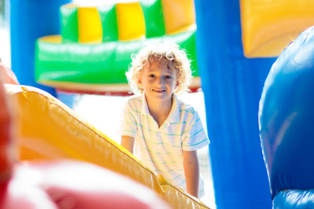 istock Child jumping on playground trampoline. Kids jump. 1461765598