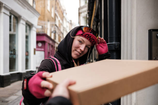 istock Portrait of bike courier delivering a parcel at flat door. 1461776607
