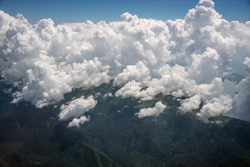 Aerial view of the giant clouds over the mountains, airplane point of view