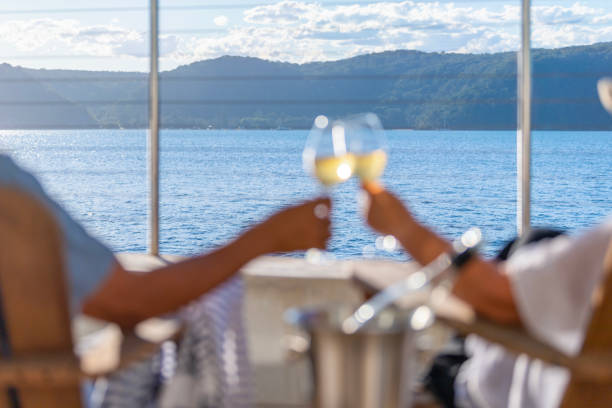 istock Couple relaxing and drinking wine on deck chairs in an over water bungalow. 1461779546