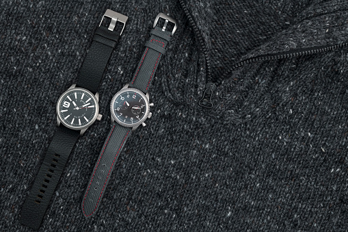 Sportive wristwatches placed on textured wool background