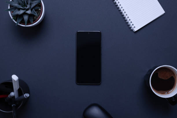 istock Blank mobile phone on black desk surrounded by office supplies. Business composition, top view, flat lay representing the integration of technology in contemporary work environments 1461784921