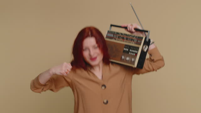 Woman using retro tape record player to listen music, disco dancing of favorite track, having fun